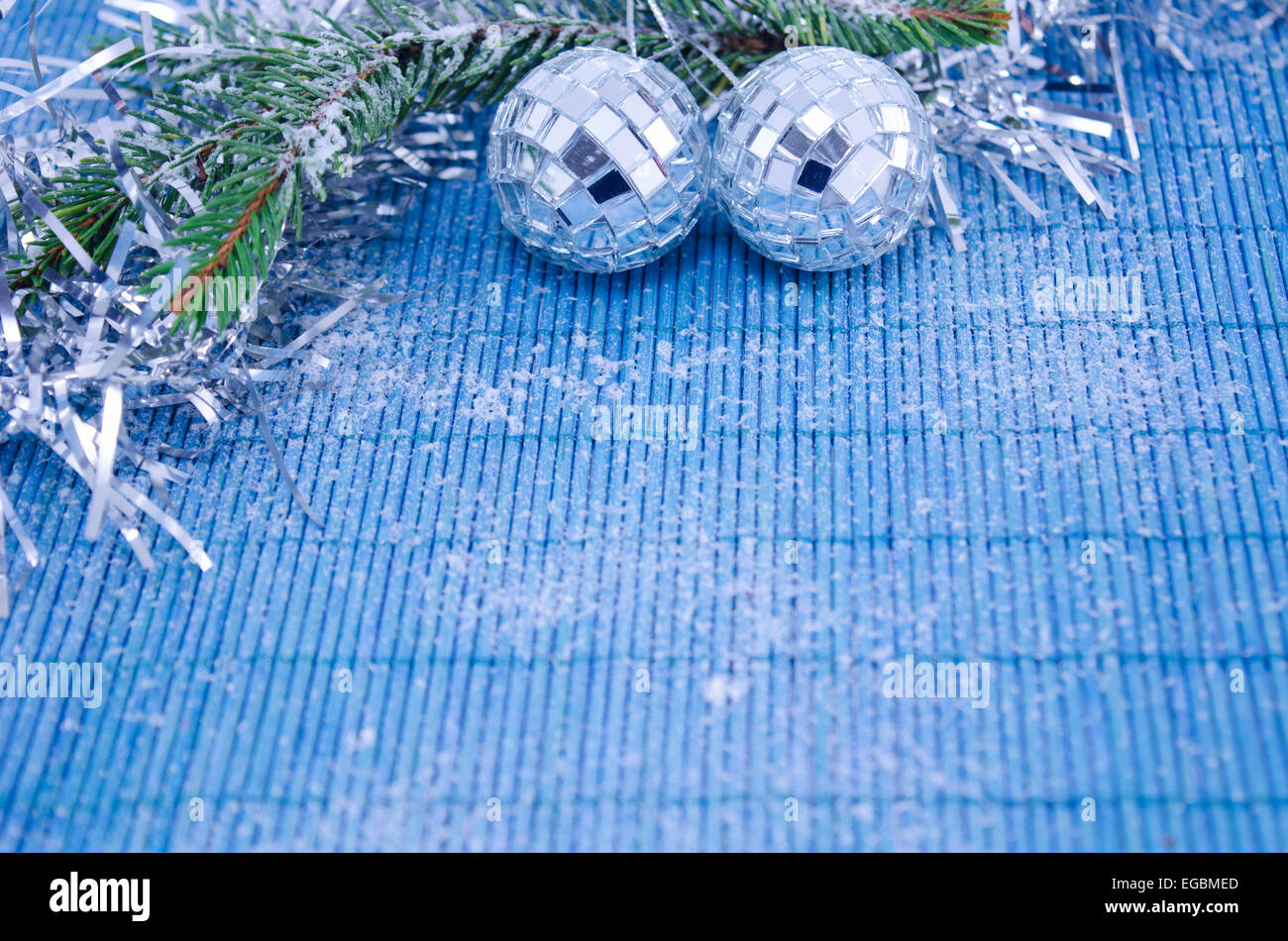 Due brillanti discoteca palle su un ramo di abete ricoperti di neve su sfondo bianco Foto Stock