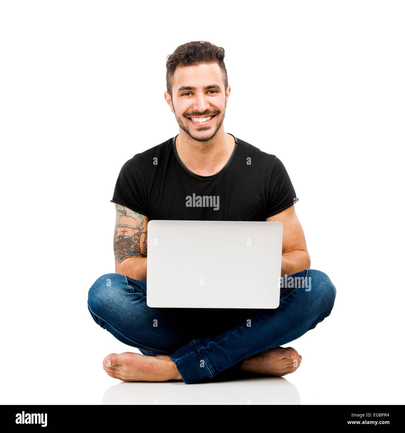 Latino uomo seduto sul pavimento e lavorare con un computer portatile Foto Stock