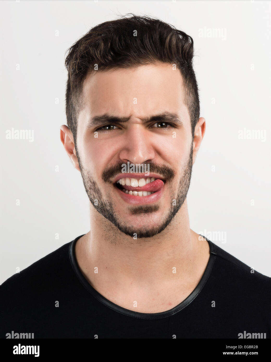 Ritratto in studio di un bel giovane con un MAD face Foto Stock