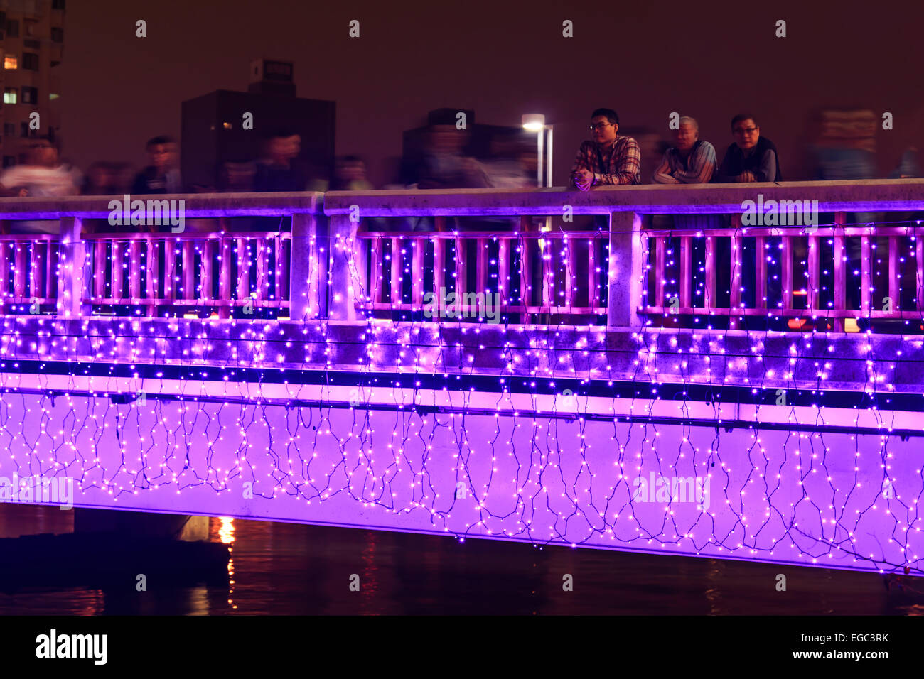 Kaohsiung, Taiwan. Il 22 febbraio, 2015. La gente che camminava sul ponte mediante il fiume dell'amore di Kaohsiung durante i festeggiamenti per il capodanno cinese. Il Capodanno cinese è un importante festival cinese ha celebrato presso la volta del calendario cinese. In Cina, è anche noto come il Festival di Primavera, la traduzione letterale del moderno nome cinese. Credito: Fabio Nodari/Alamy Live News Foto Stock