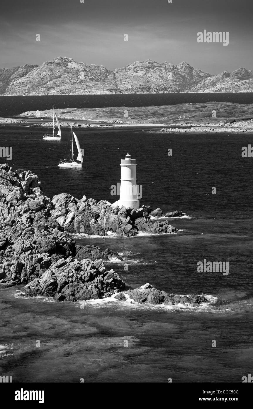 Costa Smeralda, Sardegna, Italia. 9/2011. Barche a vela e il vecchio faro lungo la costa vicino a Porto Cervo Arzachena Foto Stock