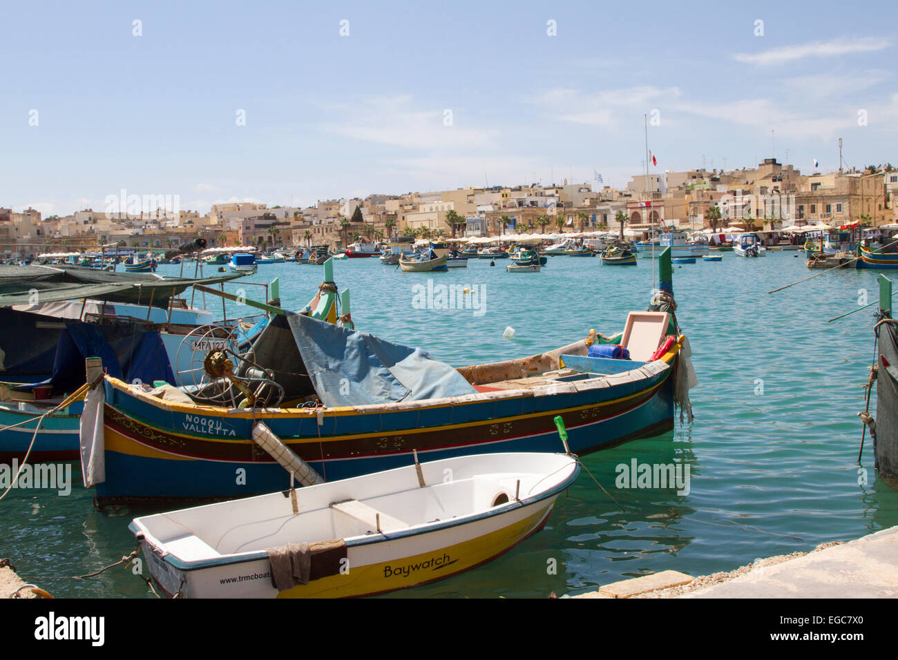 Il pittoresco paesaggio di numerose barche tradizionali e moderne nel porto di Marsaxlokk, Malta Foto Stock