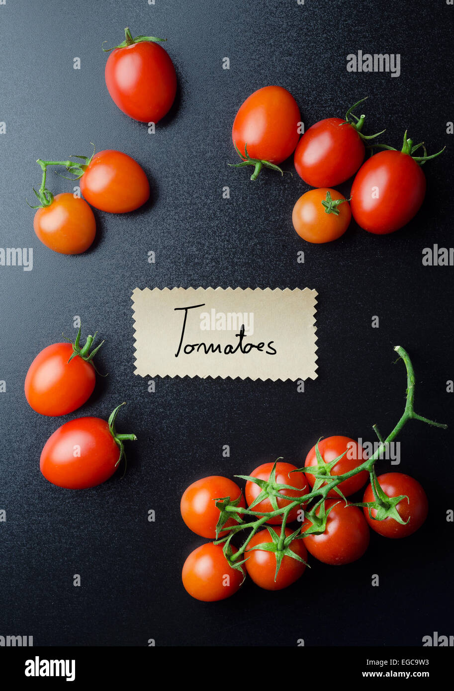 Pomodori ciliegia e nota manoscritta sulla lavagna nera, sopra visualizza Foto Stock