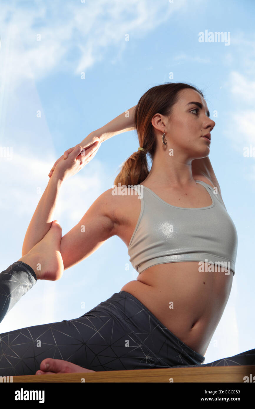 Donna pratica un difficile posa yoga Foto Stock