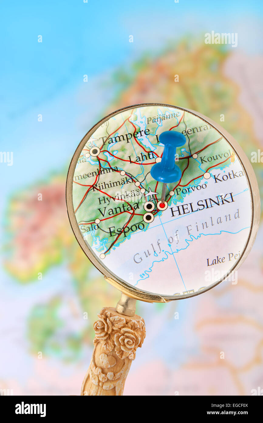 Blu Tack sulla mappa della Scandinavia con lente di ingrandimento cercando in su Helsinki, Finlandia Foto Stock