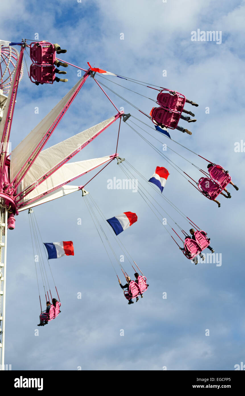 La bandiera francese vola da Carnival altalene a Fete des Tuileries a Parigi, Francia Foto Stock