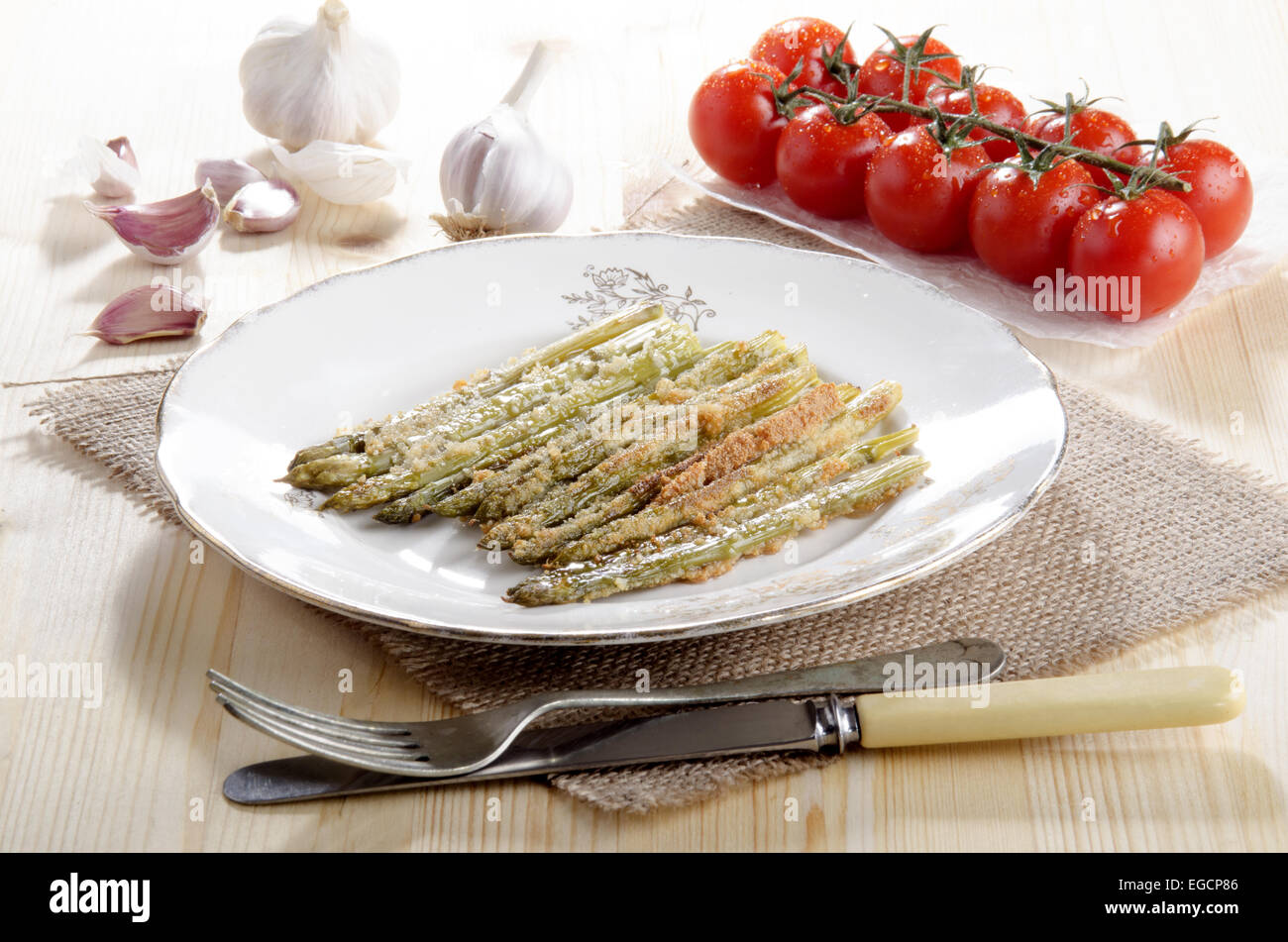 Cotta asparagi verdi con briciole di pane e formaggio parmigiano grattugiato su una piastra Foto Stock
