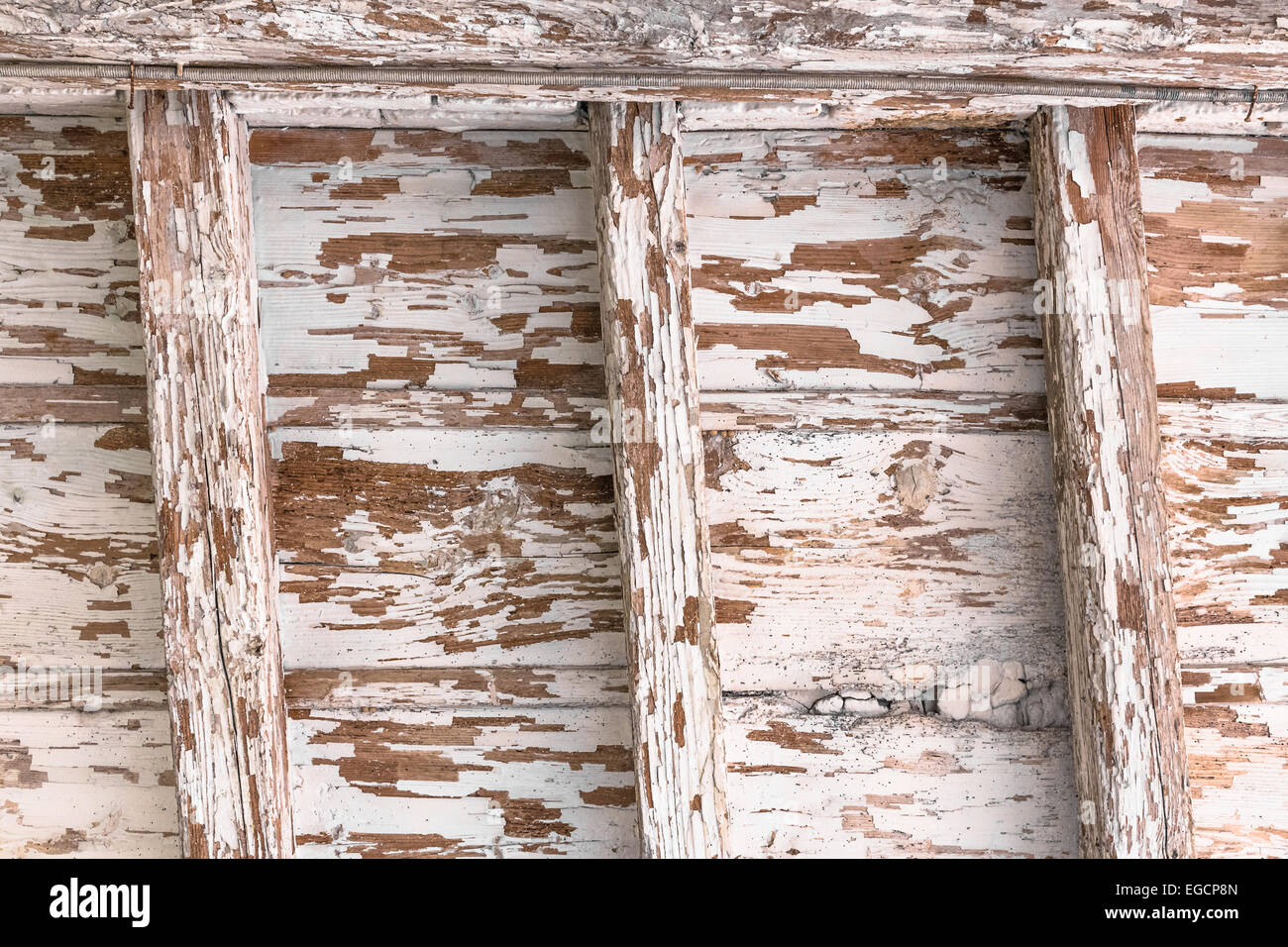 Antico soffitto in legno con travi a vista e pareti scrostate. Foto Stock