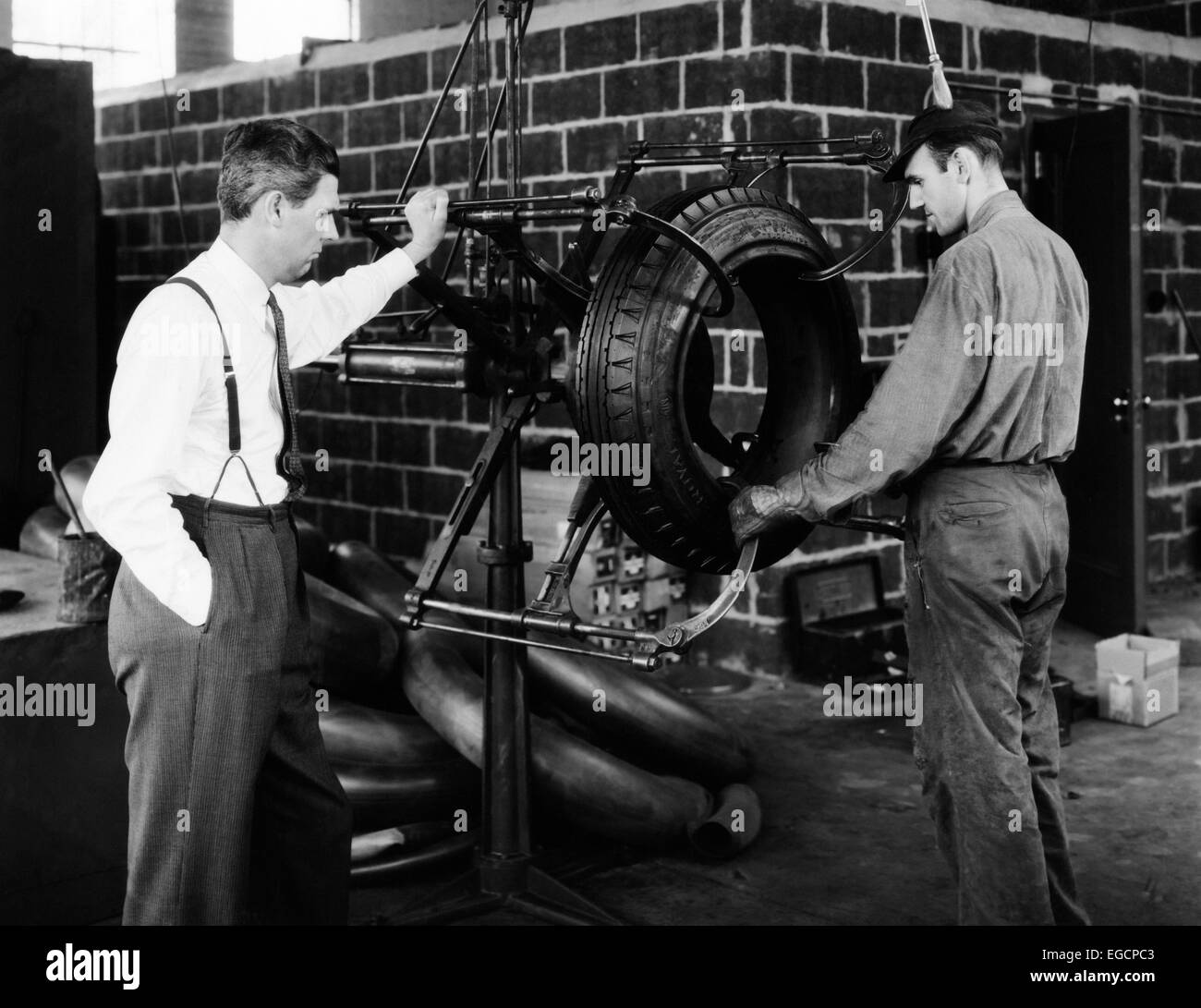 1940s 2 uomini con pneumatico in gomma la gestione della macchina di tipo MAN IN TUTA TIE ALTRI IN ABITI DA LAVORO Foto Stock