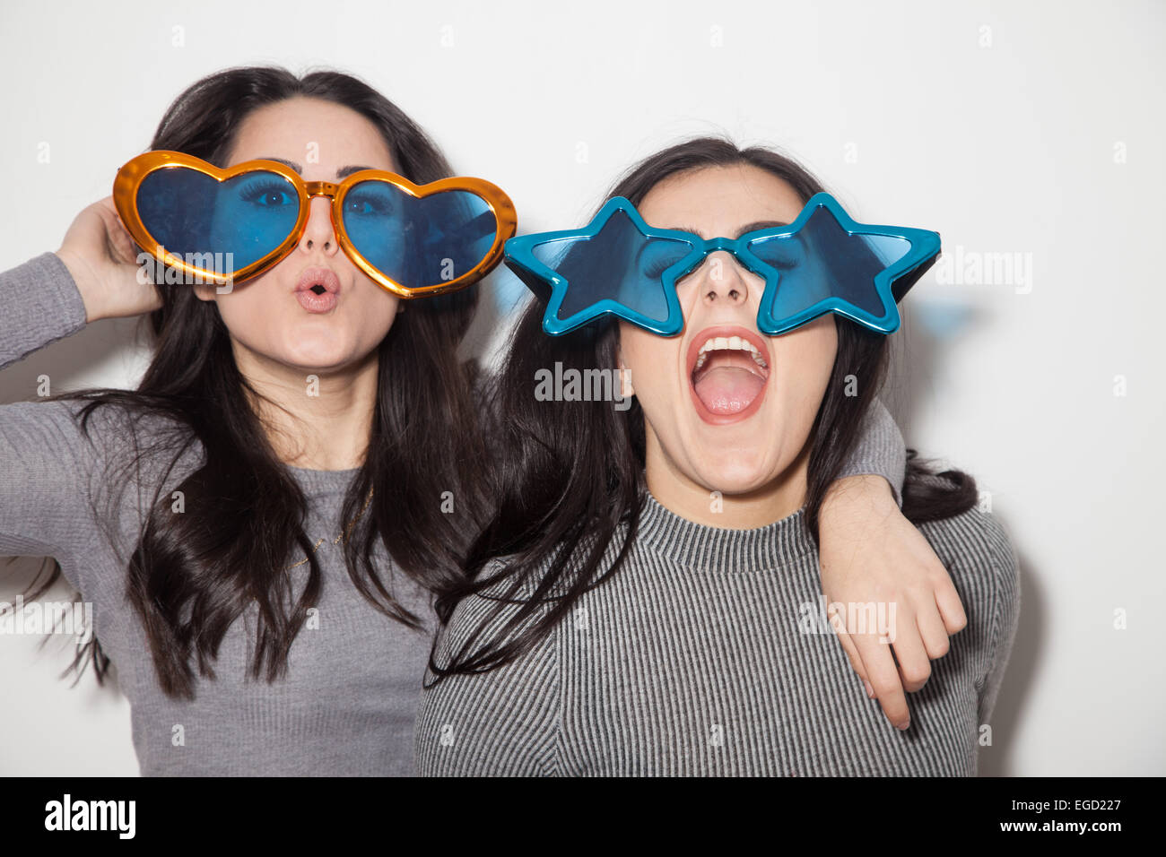 Due sorelle divertirsi insieme commedia indossa occhiali oversize. Foto Stock