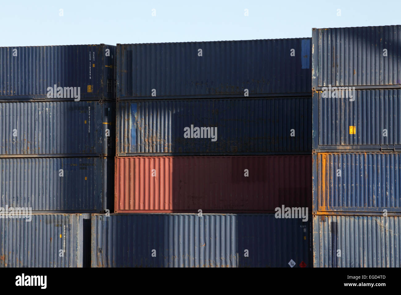 Contrastanti e colorato di pile di contenitori di spedizione ammucchiati uno a Barcellona docks. Foto Stock