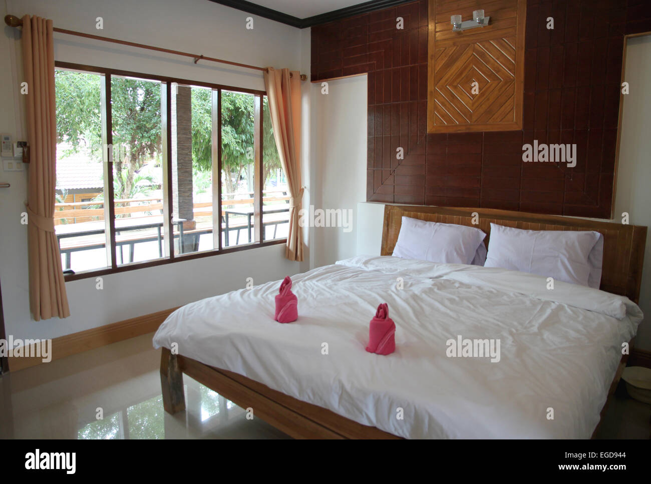 Camera da letto in legno hanno una biancheria da letto bianca. Foto Stock