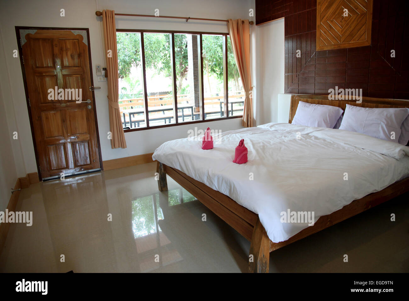 Camera da letto in legno hanno una biancheria da letto bianca. Foto Stock