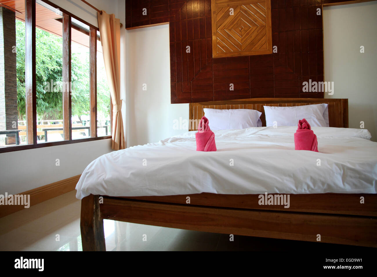 Camera da letto in legno hanno una biancheria da letto bianca. Foto Stock