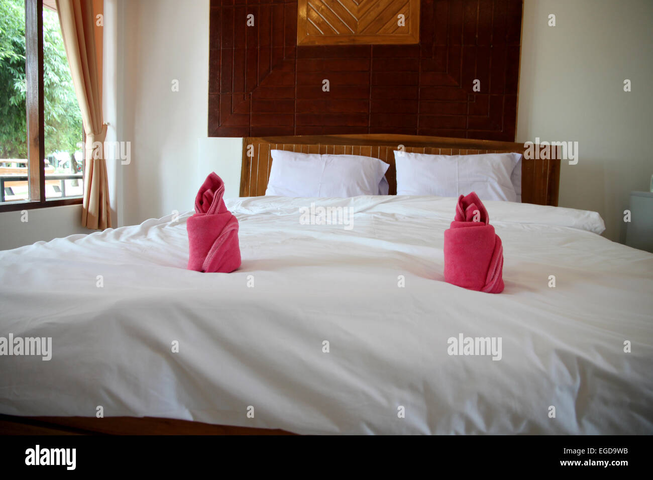 Camera da letto in legno hanno una biancheria da letto bianca. Foto Stock