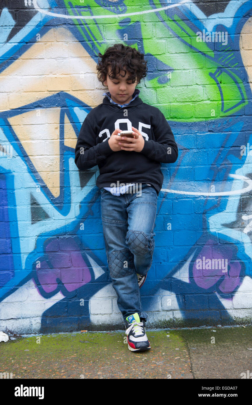 8 anno vecchio ragazzo tramite telefono cellulare Foto Stock