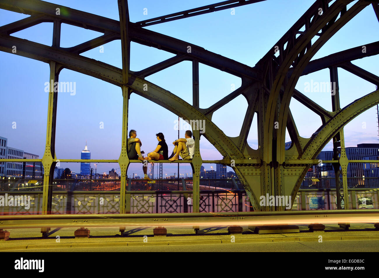Gente seduta sul ponte di hacker in serata, Monaco di Baviera, Germania Foto Stock