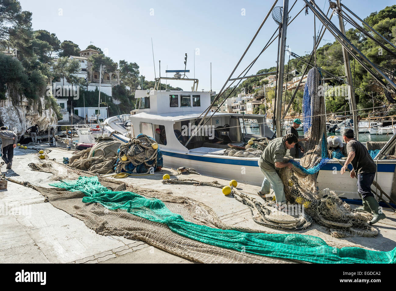 I pescatori lo smistamento delle reti a Cala Figuera, vicino a Santanyi, Maiorca, SPAGNA Foto Stock