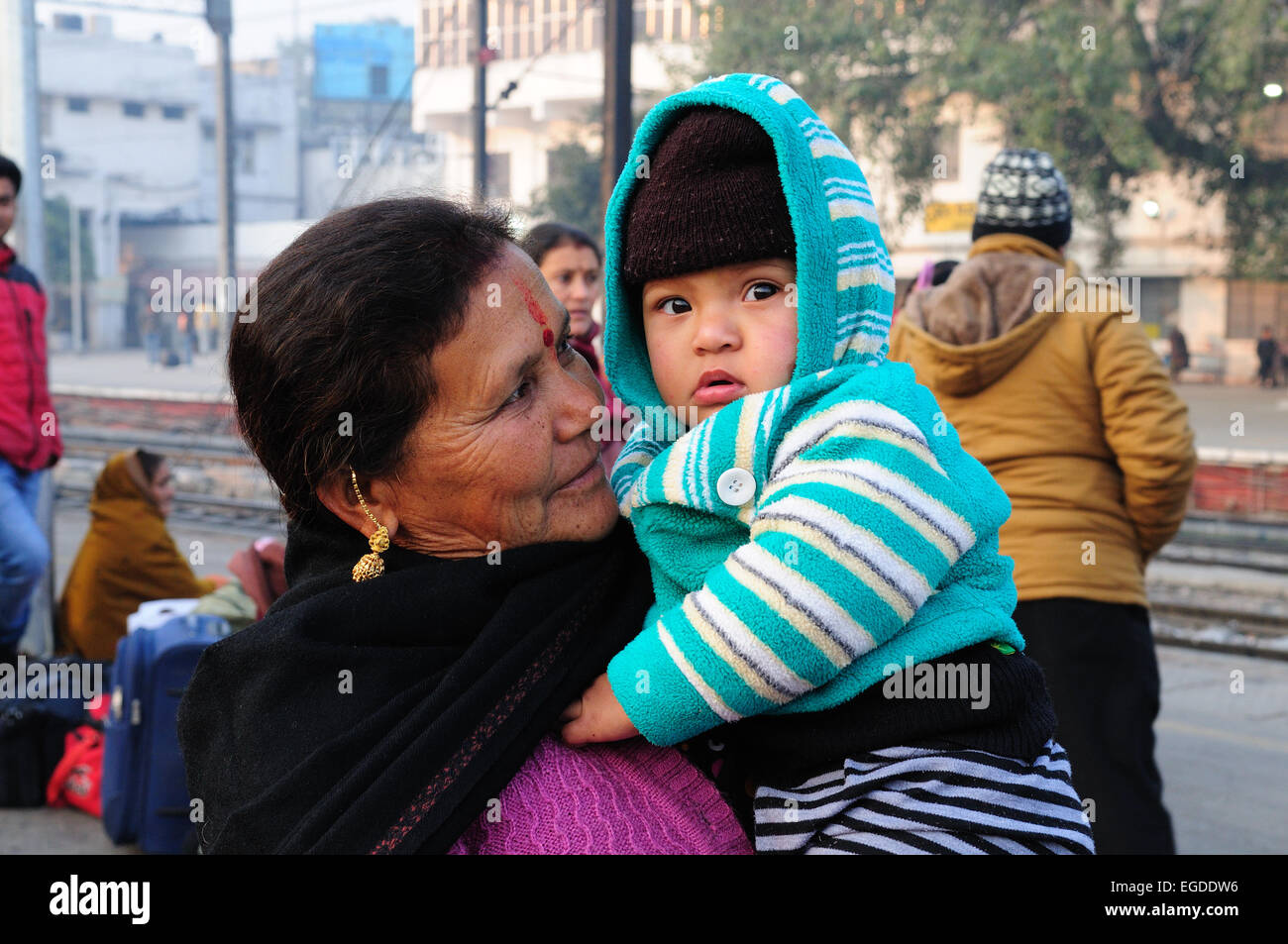 Little Indian baby boy nelle sue braccia nonne in attesa di un treno a Delhi Stazione ferroviaria India Foto Stock