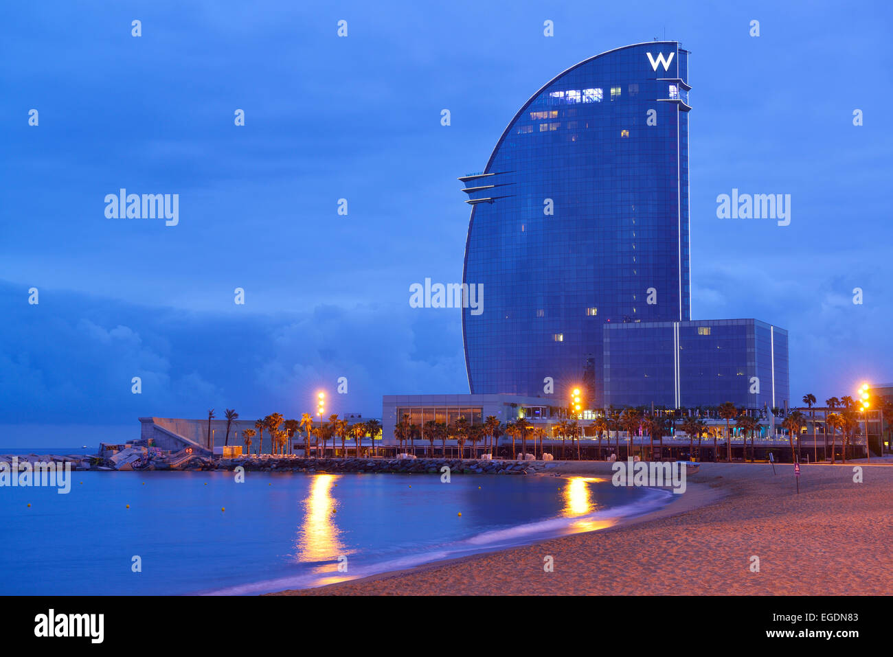 Hotel W e spiaggia, illuminata di notte, architetto Ricardo Bofill, Barceloneta, Barcellona, in Catalogna, Spagna Foto Stock
