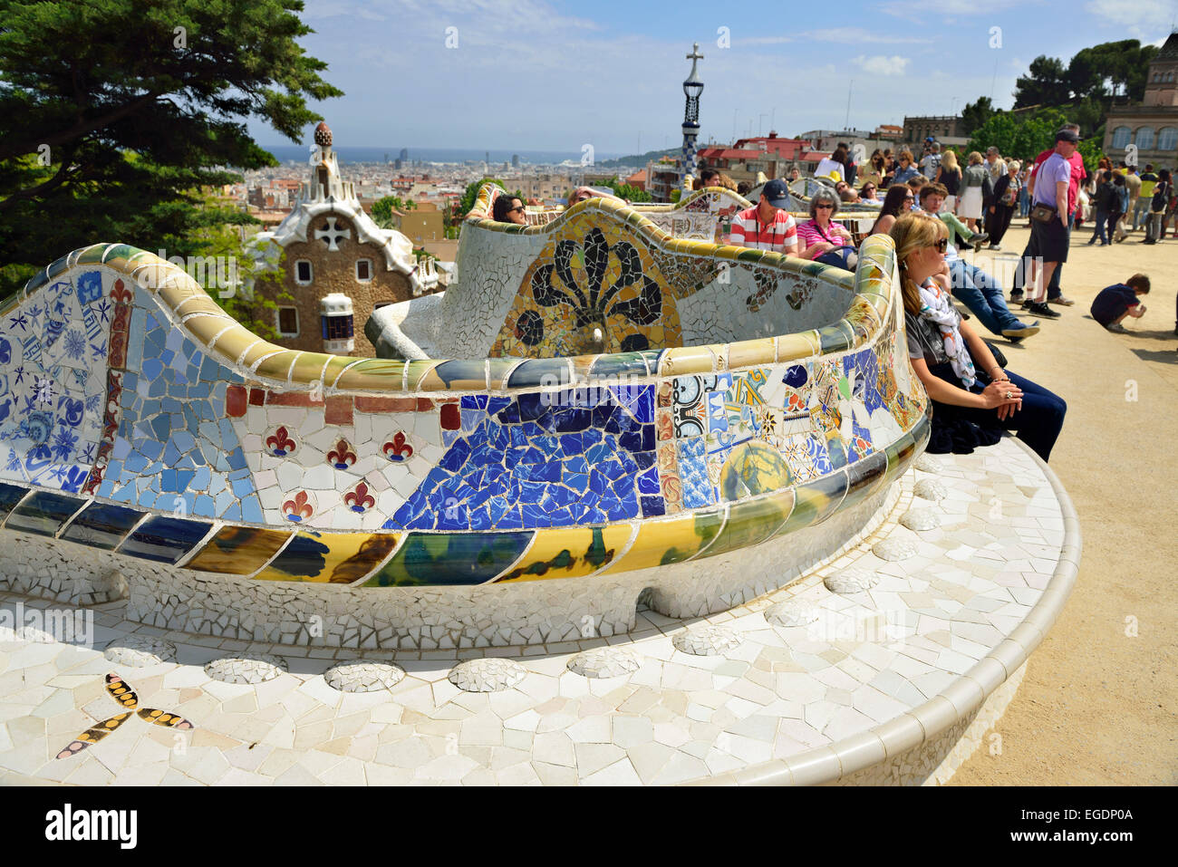 Gente seduta sul mosaico banco di serpente, Parco Guell, architetto Antoni Gaudi, Sito Patrimonio Mondiale dell'Unesco Parco Guell, Catalano architettura modernista, Art Nouveau, Barcellona, in Catalogna, Spagna Foto Stock