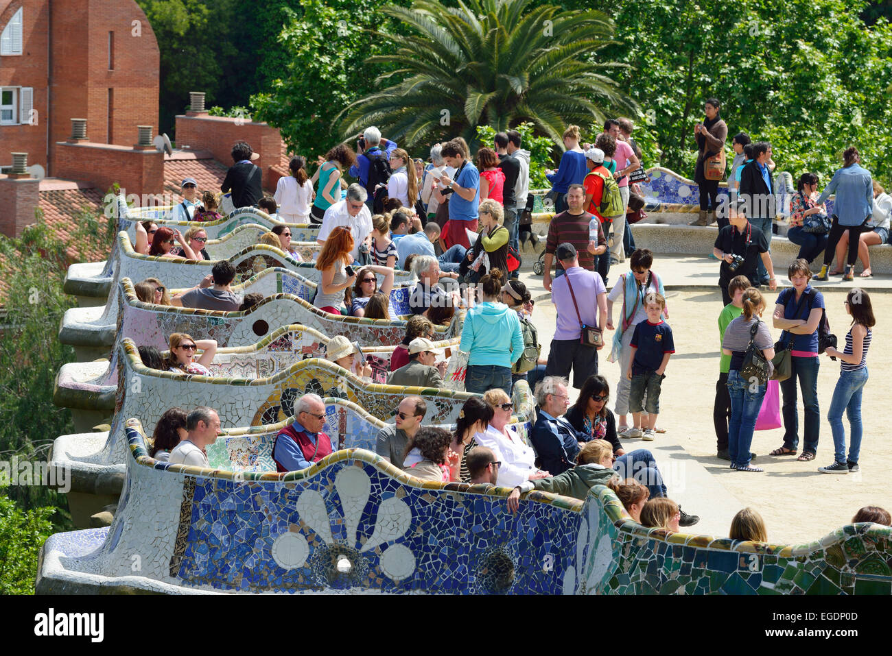 Gente seduta sul mosaico banco di serpente, Parco Guell, architetto Antoni Gaudi, Sito Patrimonio Mondiale dell'Unesco Parco Guell, Catalano architettura modernista, Art Nouveau, Barcellona, in Catalogna, Spagna Foto Stock