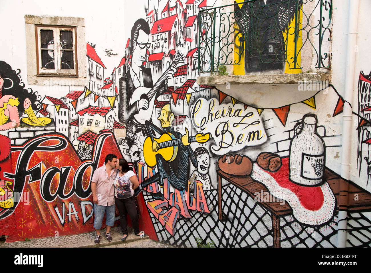 Giovane baciare davanti a un graffito murale sulla parete dei passaggi di collegamento tra la Baixa e il quartiere di Alfama, Lisbona, Lisboa, Portogallo Foto Stock