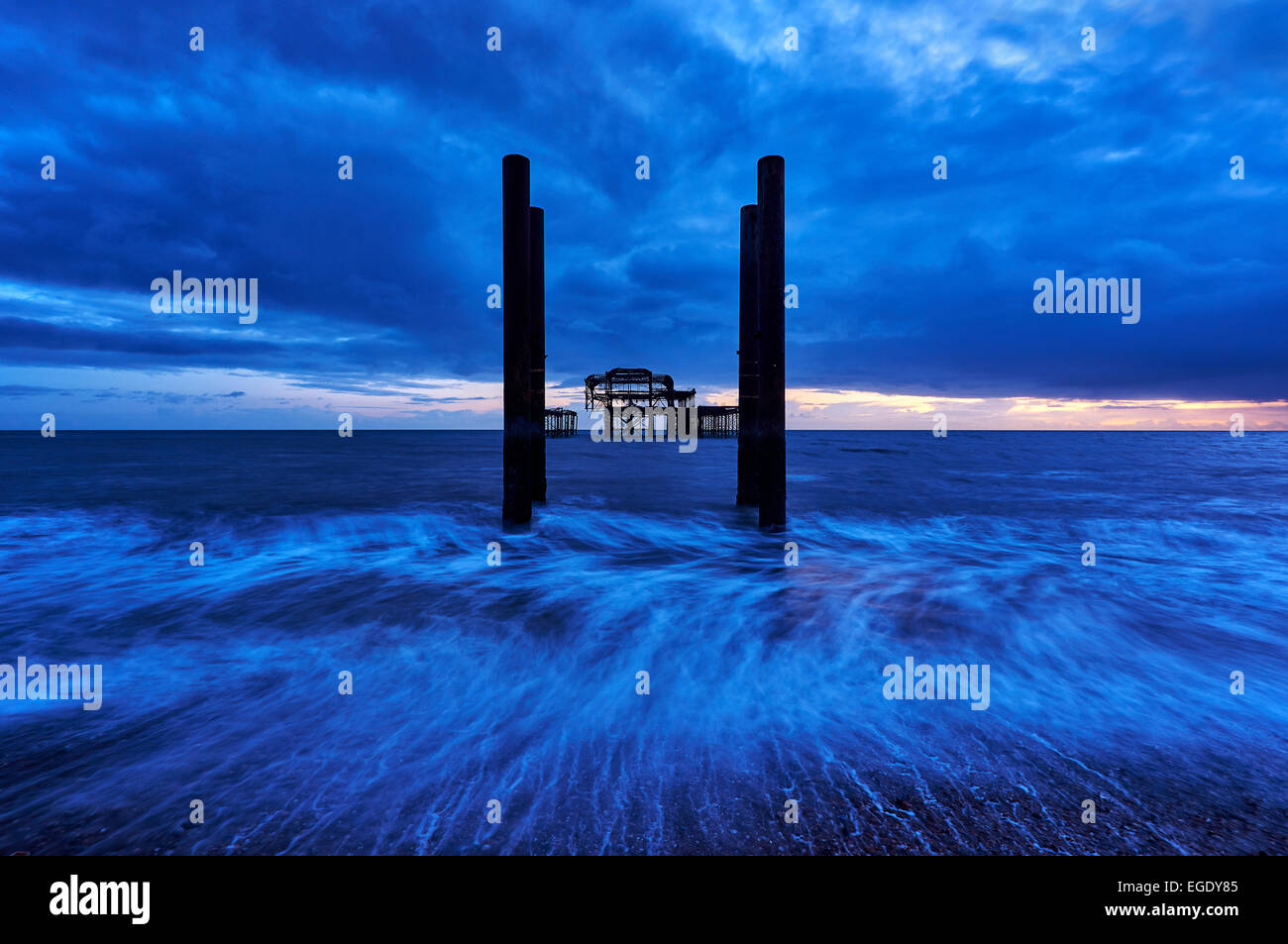 Decadimento rimane di Brighton il Molo Ovest al tramonto con la marea. Foto Stock