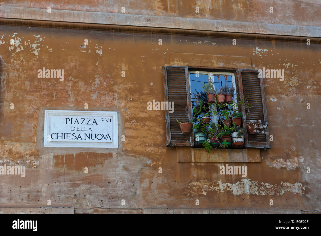 La parte esterna di un tradizionale palazzo italiano con una finestra decorata e persiane, Roma, Italia. Foto Stock