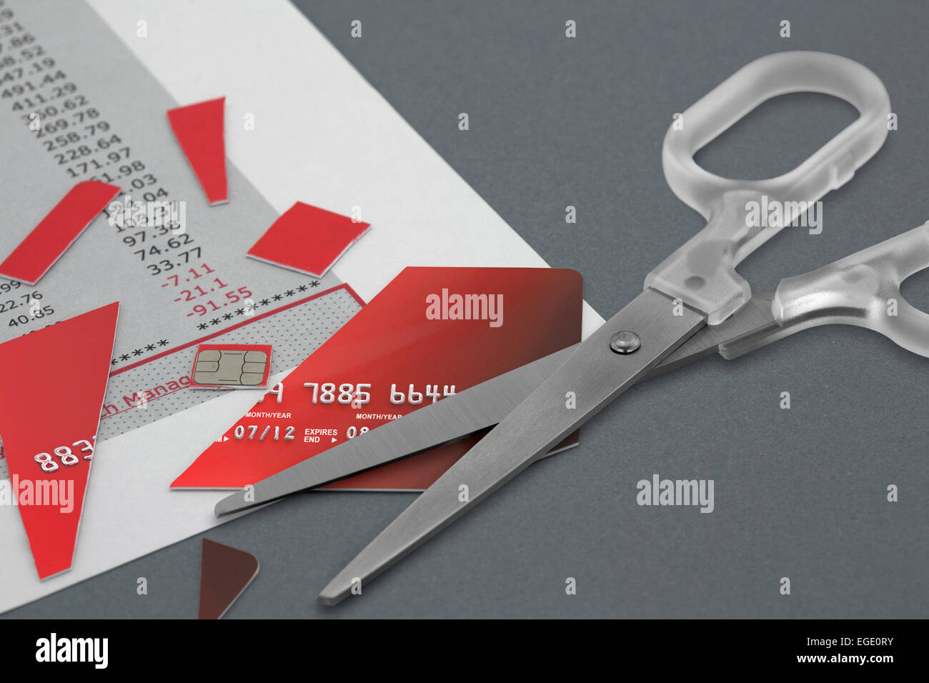 Tagliare la carta di credito e un paio di forbici sulla parte superiore di un estratto conto bancario Foto Stock