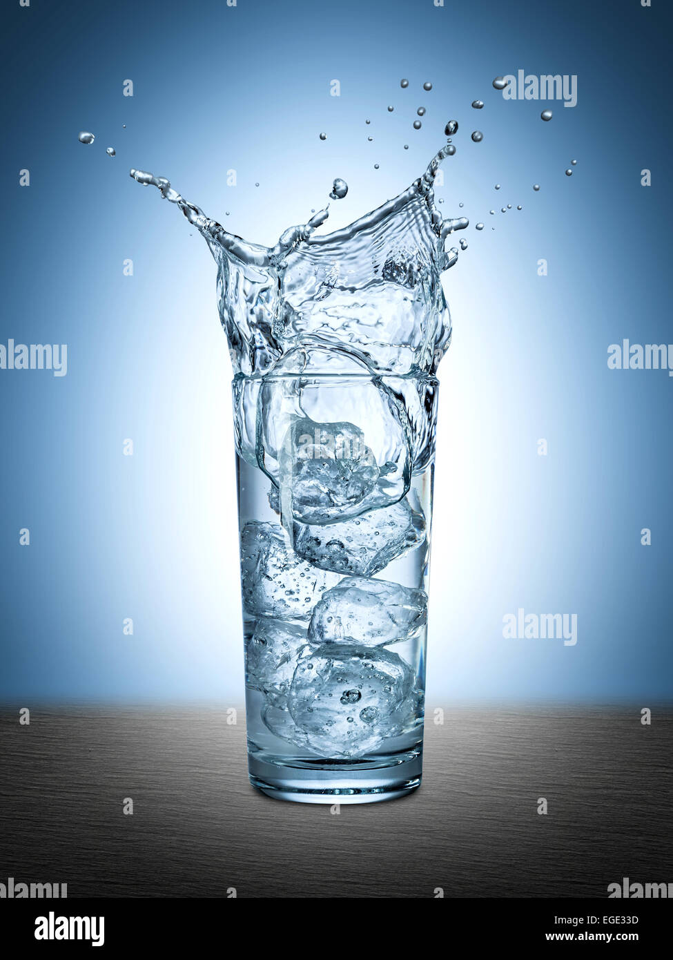 Gli spruzzi di ghiaccio in un bicchiere di acqua Foto Stock
