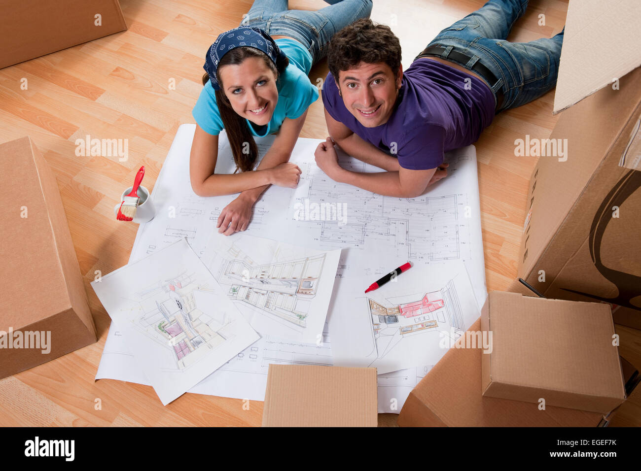Coppia giovane sul pavimento facendo piani per la nuova casa Foto Stock