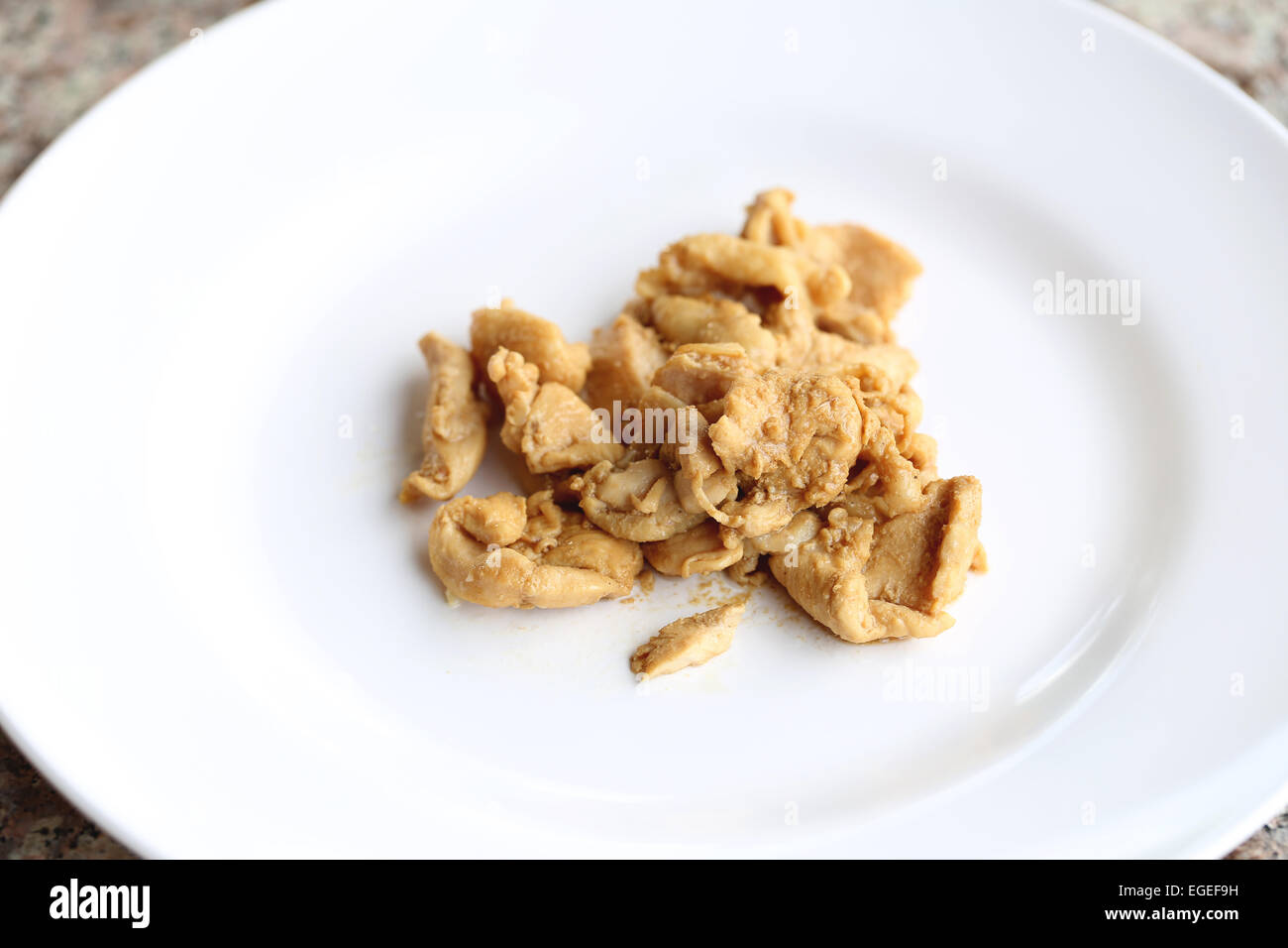 Mescolare la carne di pollo con salse in un piatto bianco. Foto Stock