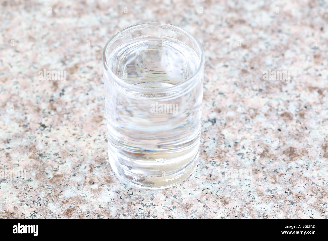 Bicchiere di acqua posta su una tavola di marmo. Foto Stock