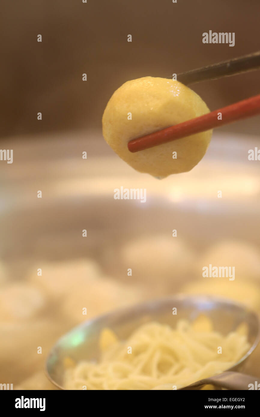 Polpetta su bacchette tagliate a cubetti in sukiyaki pot. Foto Stock