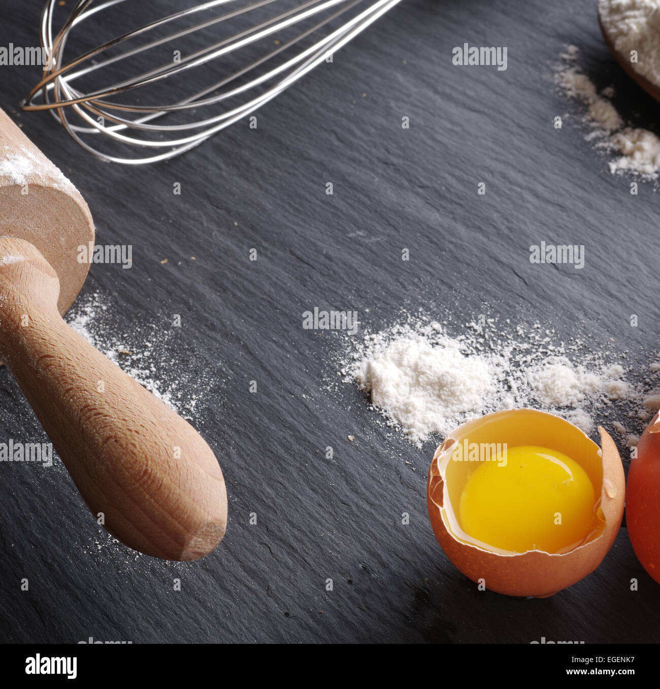 Preparazione di pasta. La cottura Ingredienti: uova e farina sul bordo nero. Foto Stock