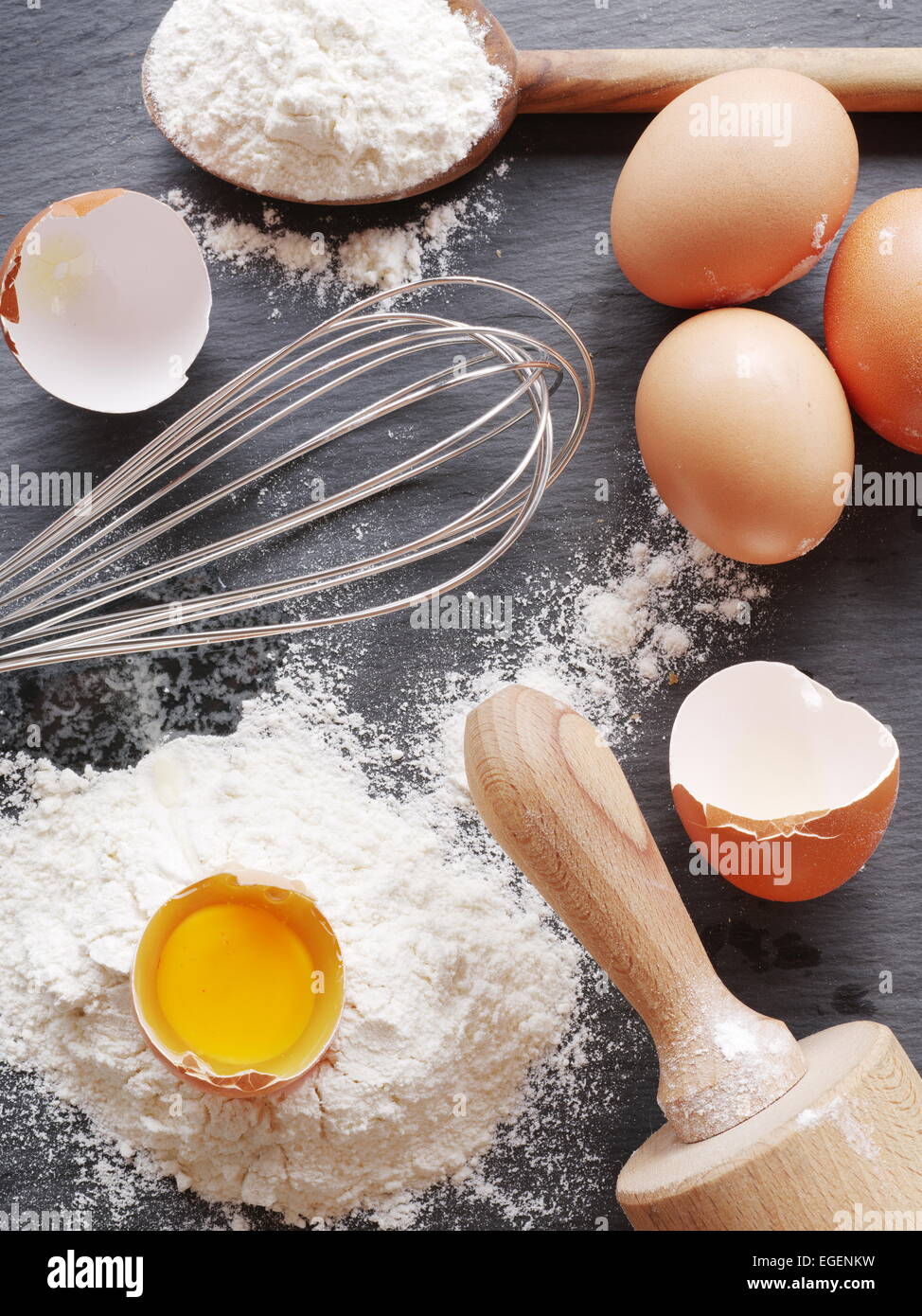 Preparazione di pasta. La cottura Ingredienti: uova e farina sul bordo nero. Foto Stock