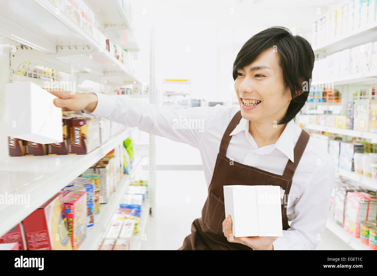Un giovane giapponese uomo che lavora al negozio di convenienza Foto Stock