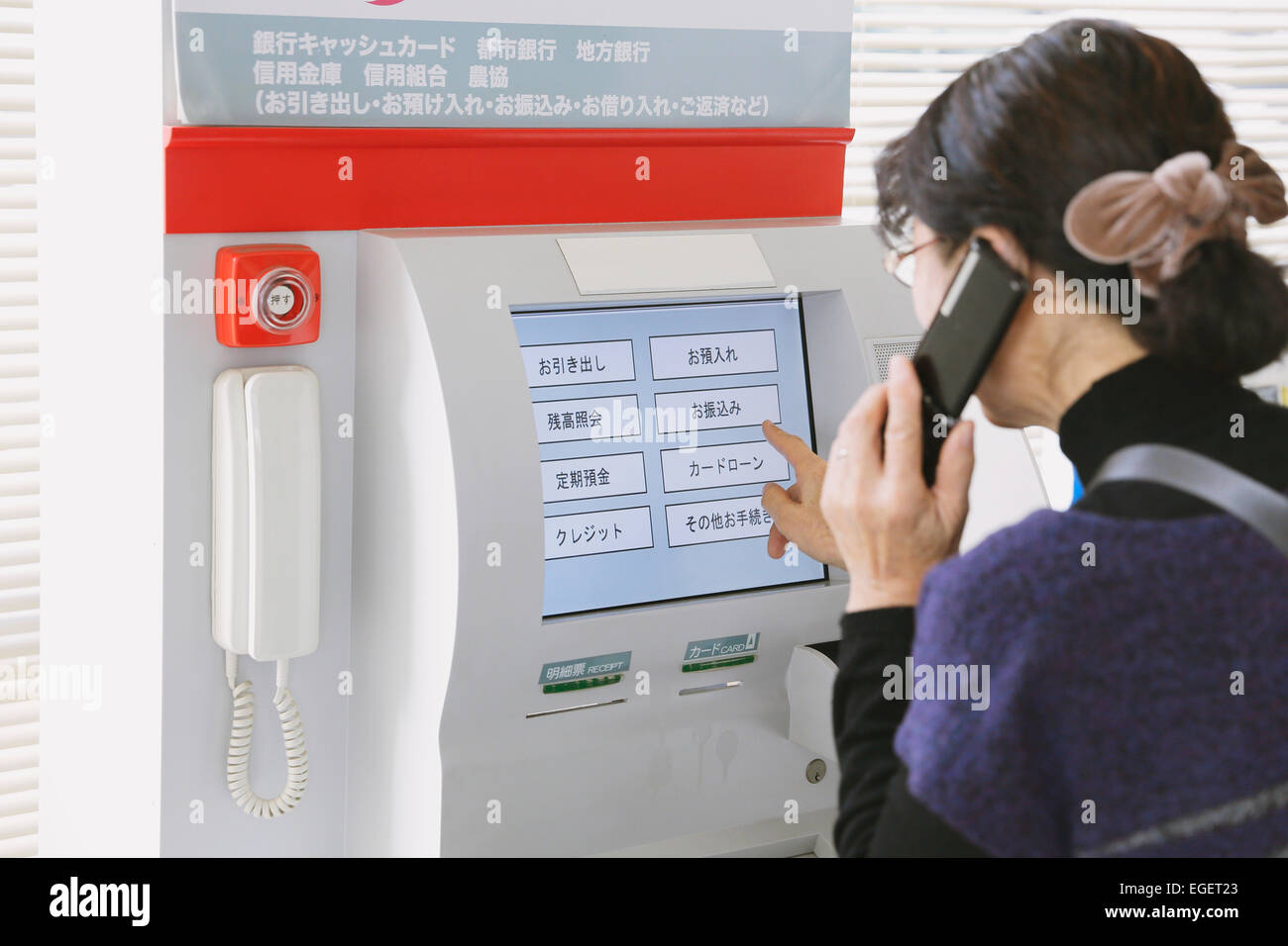 Donna Giapponese utilizzando ATM in un negozio Foto Stock