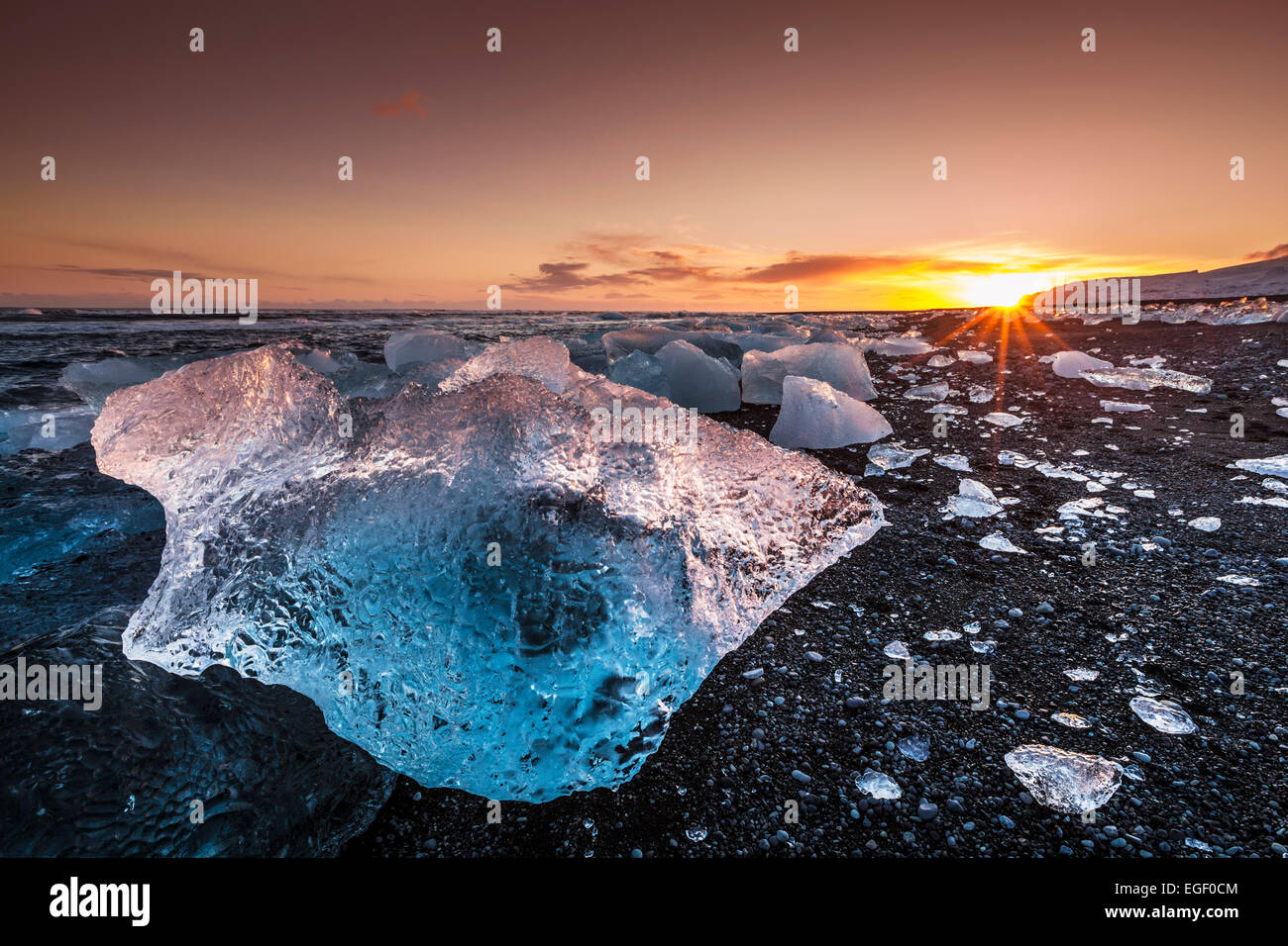 Rotto il ghiaccio da lavato fino iceberg sulla Jokulsarlon spiaggia nera al tramonto Jokulsarlon sud est dell'Islanda Foto Stock