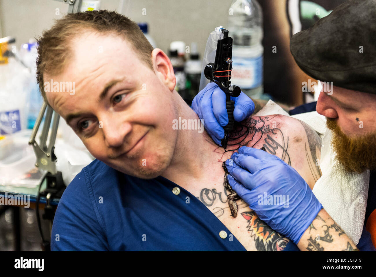 Un uomo tatuato sulla sua spalla al Brighton Tattoo Convention. Foto Stock