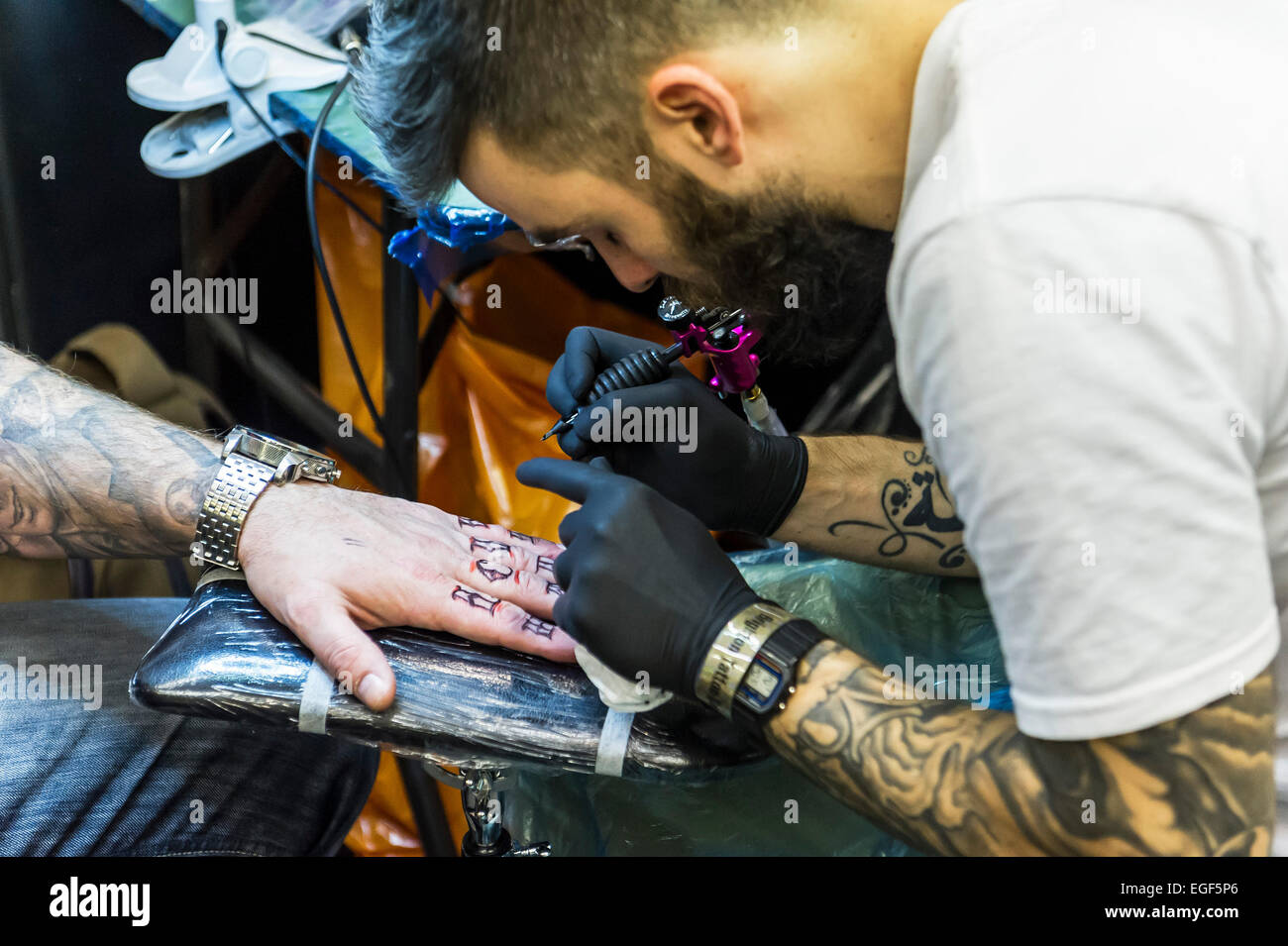 Un uomo tatuato sulla sua mano al Brighton Tattoo Convention. Foto Stock