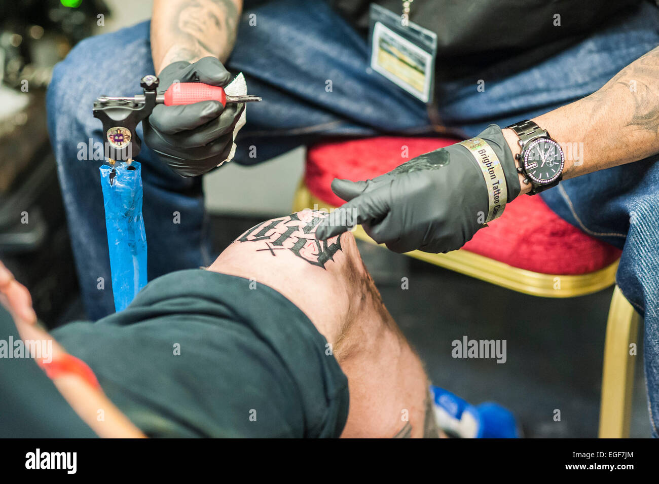 Un uomo tatuato sul suo ginocchio al Brighton Tattoo Convention. Foto Stock