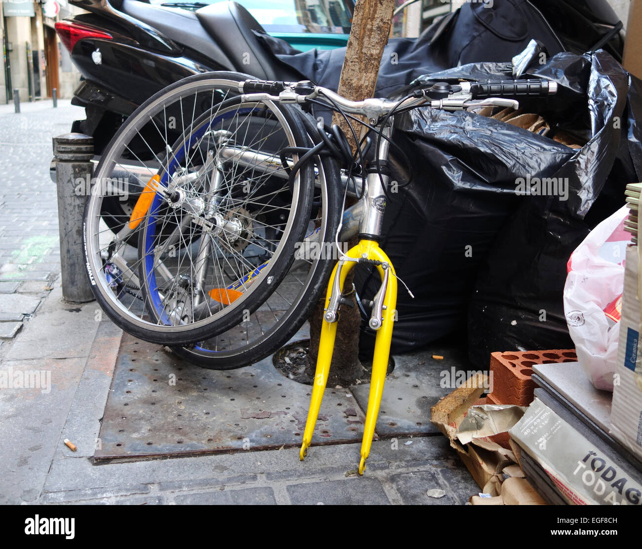 Bicicletta con ruote smontate e il cavo di bloccaggio della bicicletta, per evitare i furti di Madrid in Spagna. Foto Stock