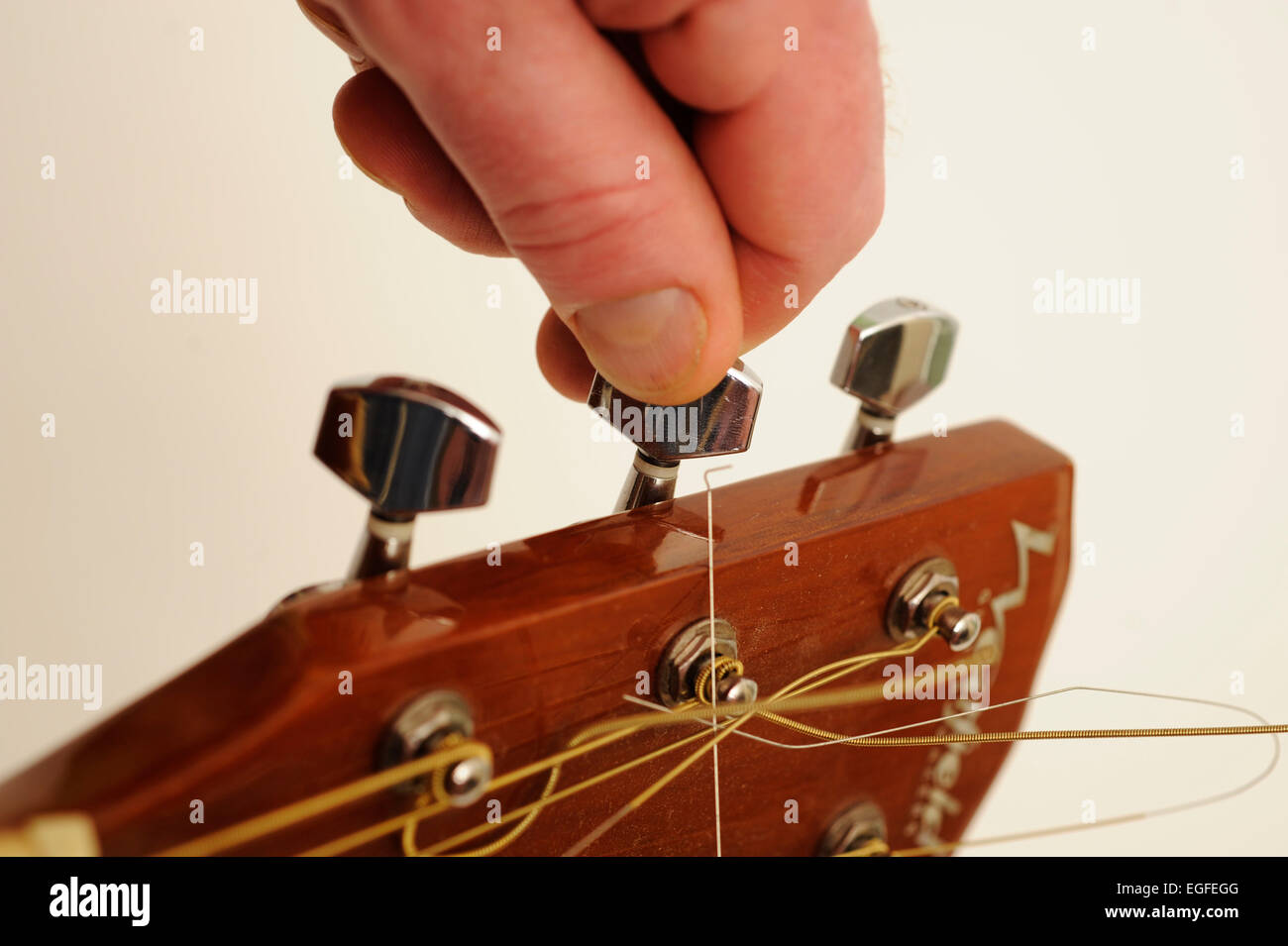 Maschio lato Tunning una chitarra acustica Foto Stock