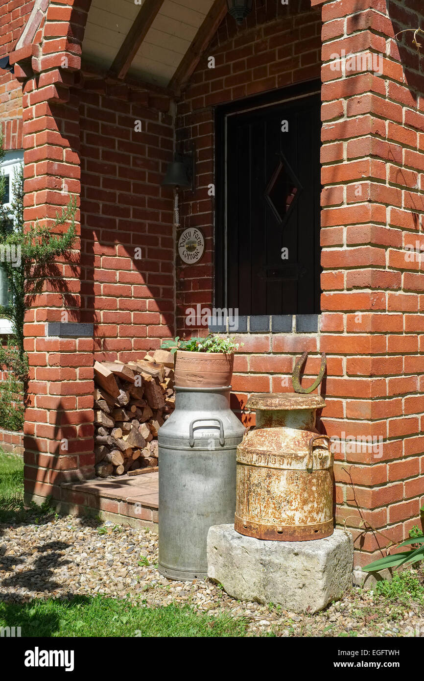 Portico di mattoni rossi Cottage di campagna con i secchi del latte Foto Stock