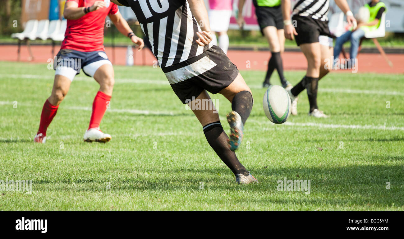 Giocatore di Rugby calci hard la palla ovale Foto Stock