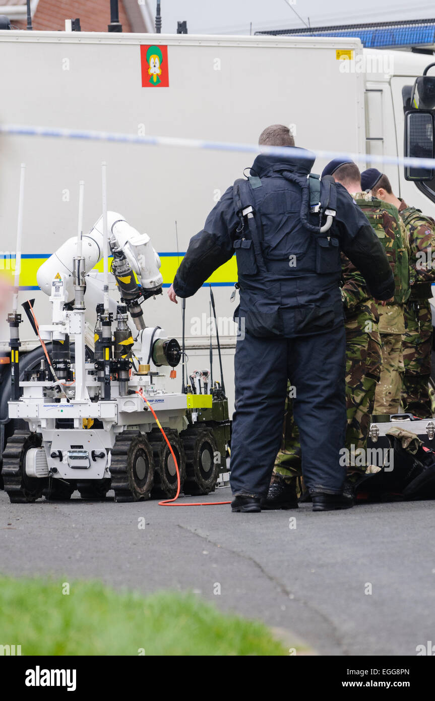 Munizioni Technical Officer indossa un a prova di bomba soddisfare prima di esaminare un tubo bomba, lasciato su un auto in Irlanda del Nord Foto Stock