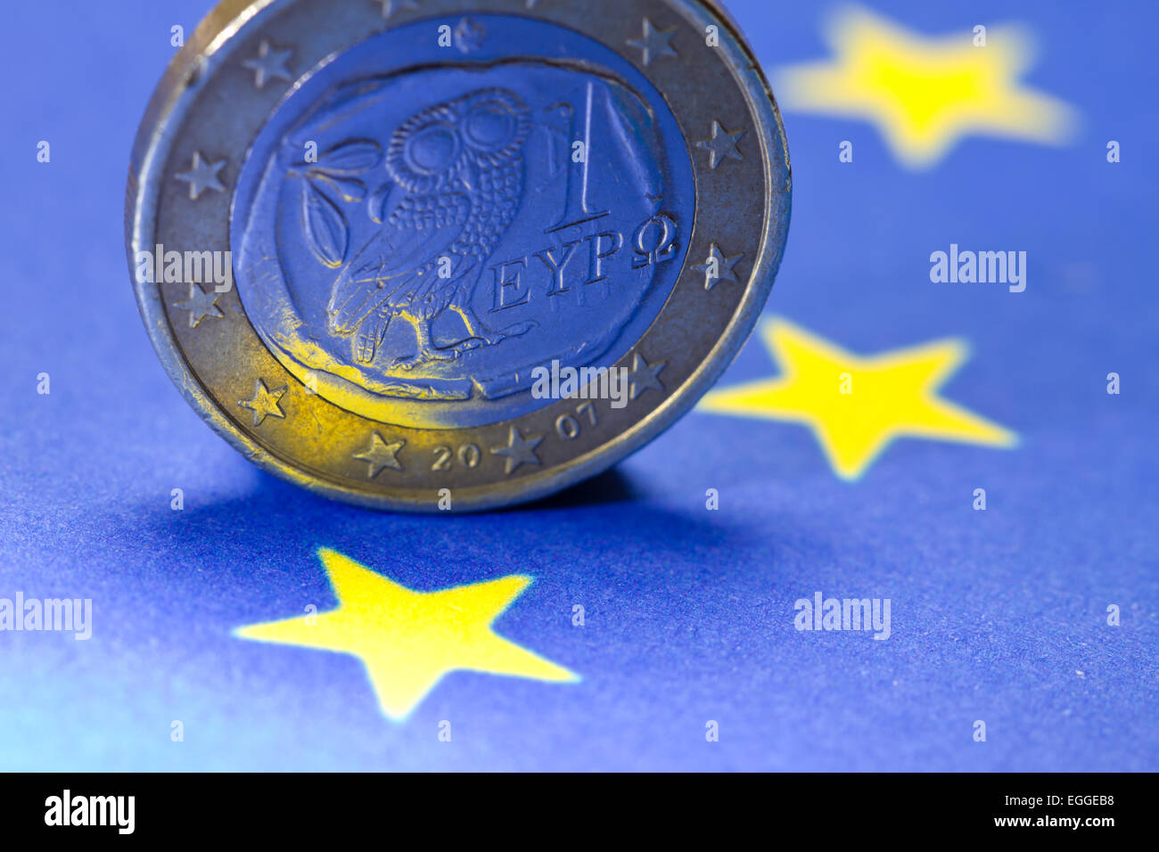 Il greco un Euro moneta sulla UE-bandiera Foto Stock
