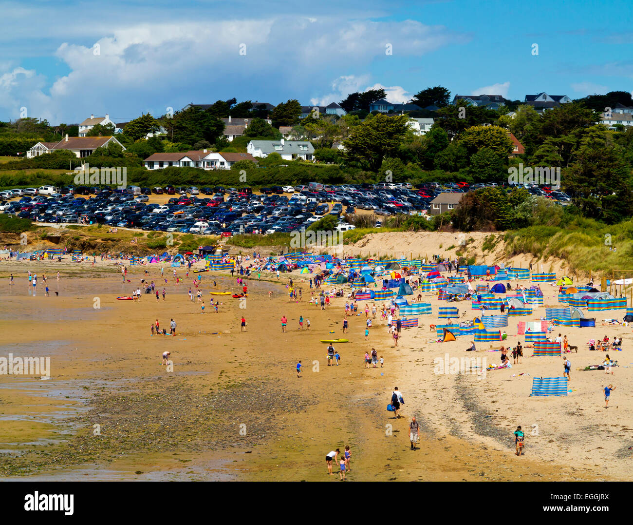 Vista mostrante affollata spiaggia e parcheggio auto presso Daymer Bay in North Cornwall Inghilterra Regno Unito nel mese di agosto Foto Stock